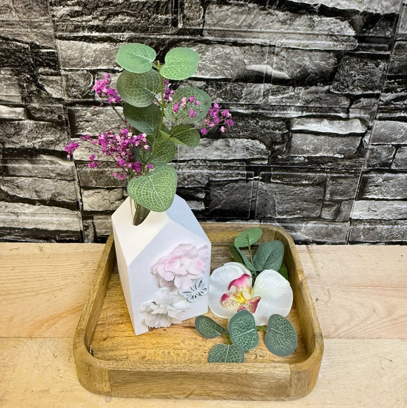 Liebevoll gestaltete Hausvase mit rosa Blüten