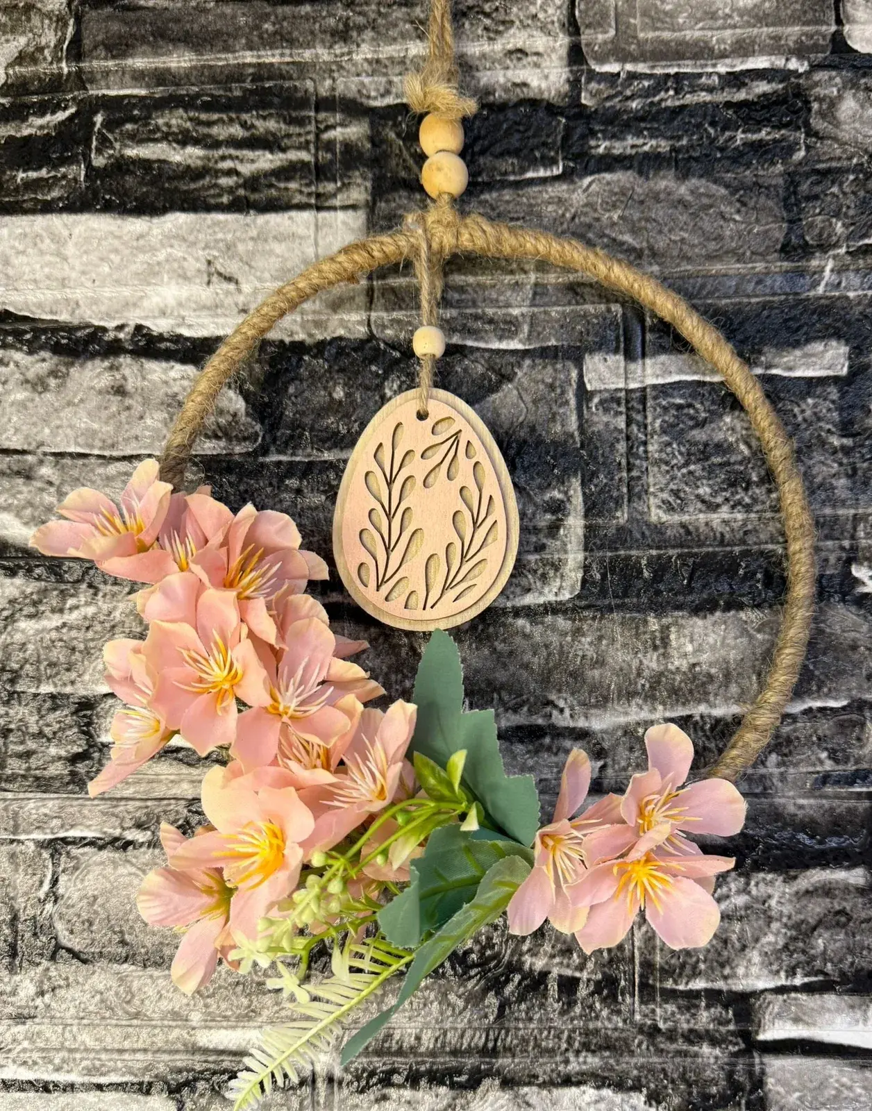 Detail eines handgemachten Kranzes aus Naturmaterialien mit zarten rosa Blüten